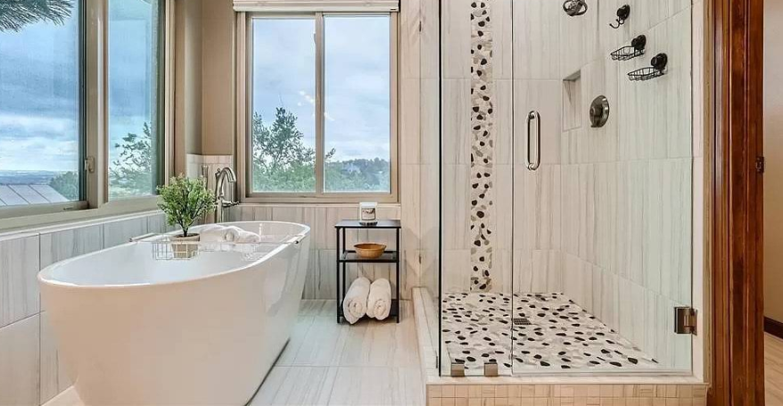 Man kneeling on floor applying mortar to tile. Construction site interior, tools visible.
