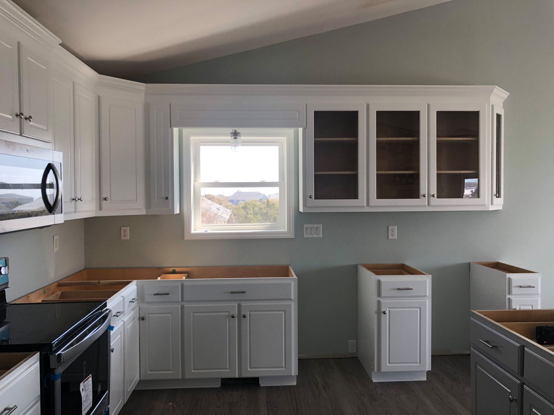 A kitchen with white cabinets and a window