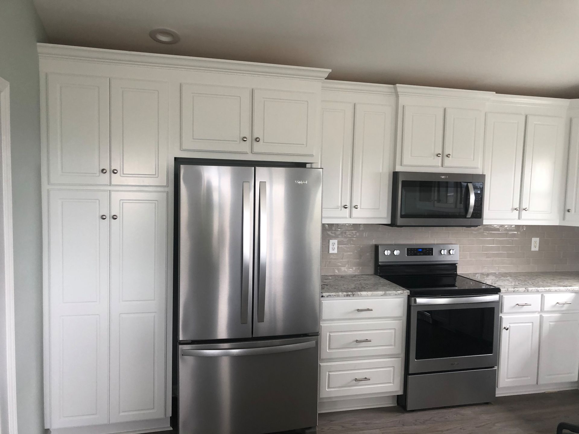 A kitchen with stainless steel appliances and white cabinets
