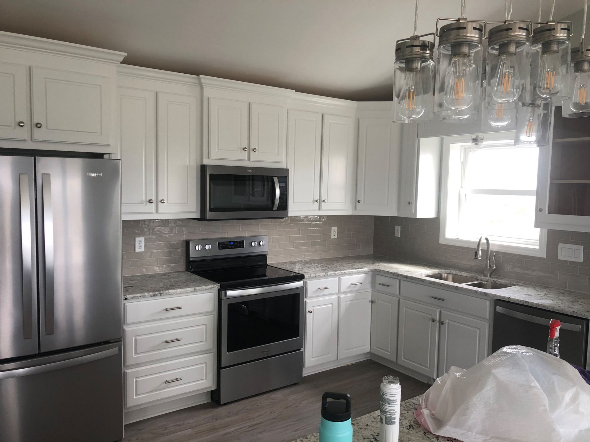 A kitchen with white cabinets and stainless steel appliances.