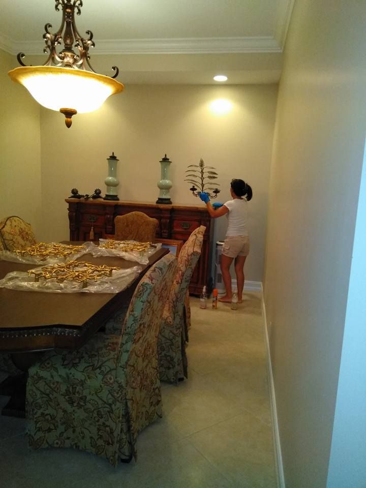 A woman is standing in a dining room with a table and chairs.
