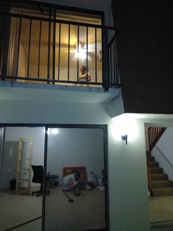 A sliding glass door leads to a balcony with a ceiling fan