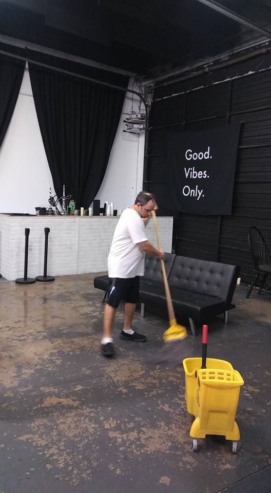 A man is cleaning a room with a mop and bucket.