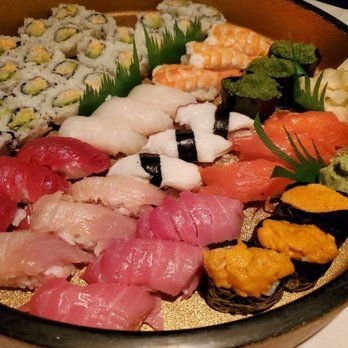 A bowl filled with a variety of sushi and rolls