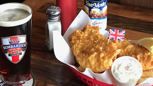 A basket of fish and a glass of beer on a table