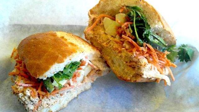 Two sandwiches are cut in half on a plate on a table.