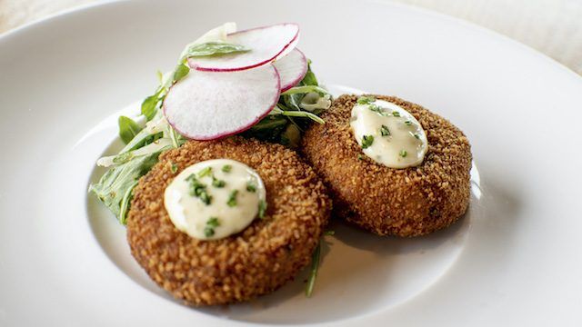 A white plate topped with fried food and radishes.