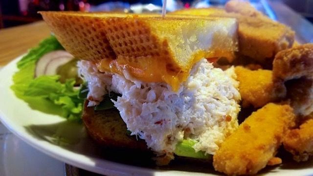 A close up of a sandwich with fried chicken on a plate.