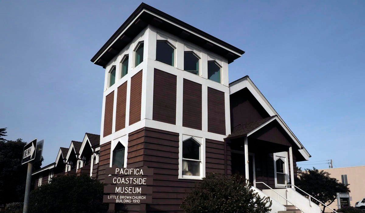 A brown and white building with a sign that says pacific coastside museum