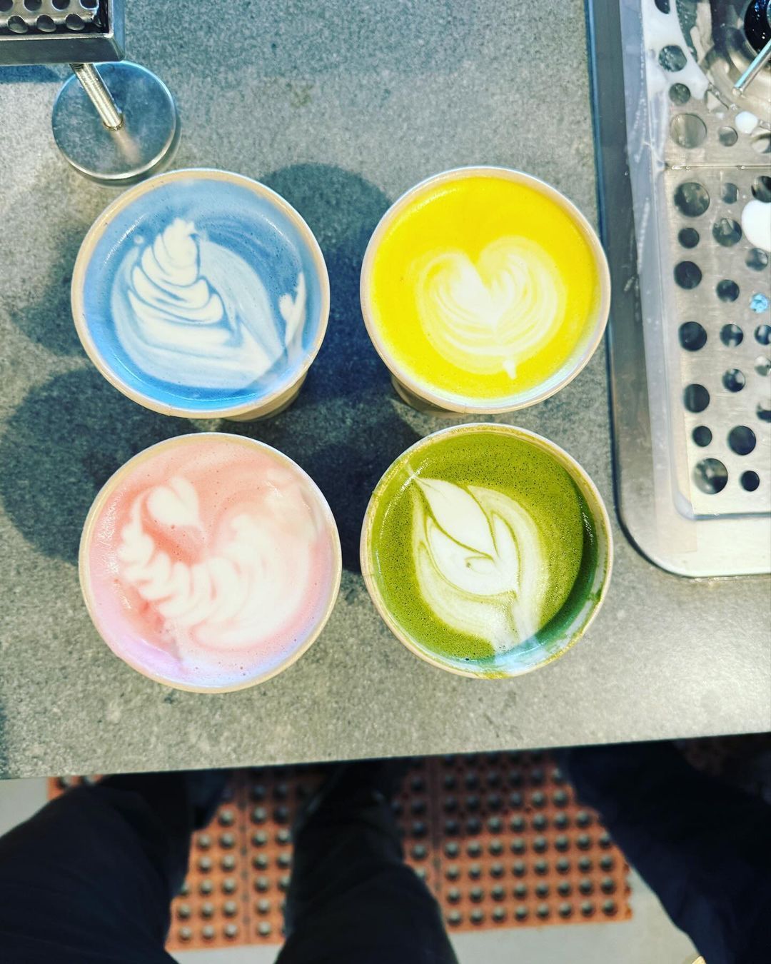 Four cups of different colored coffee on a counter top