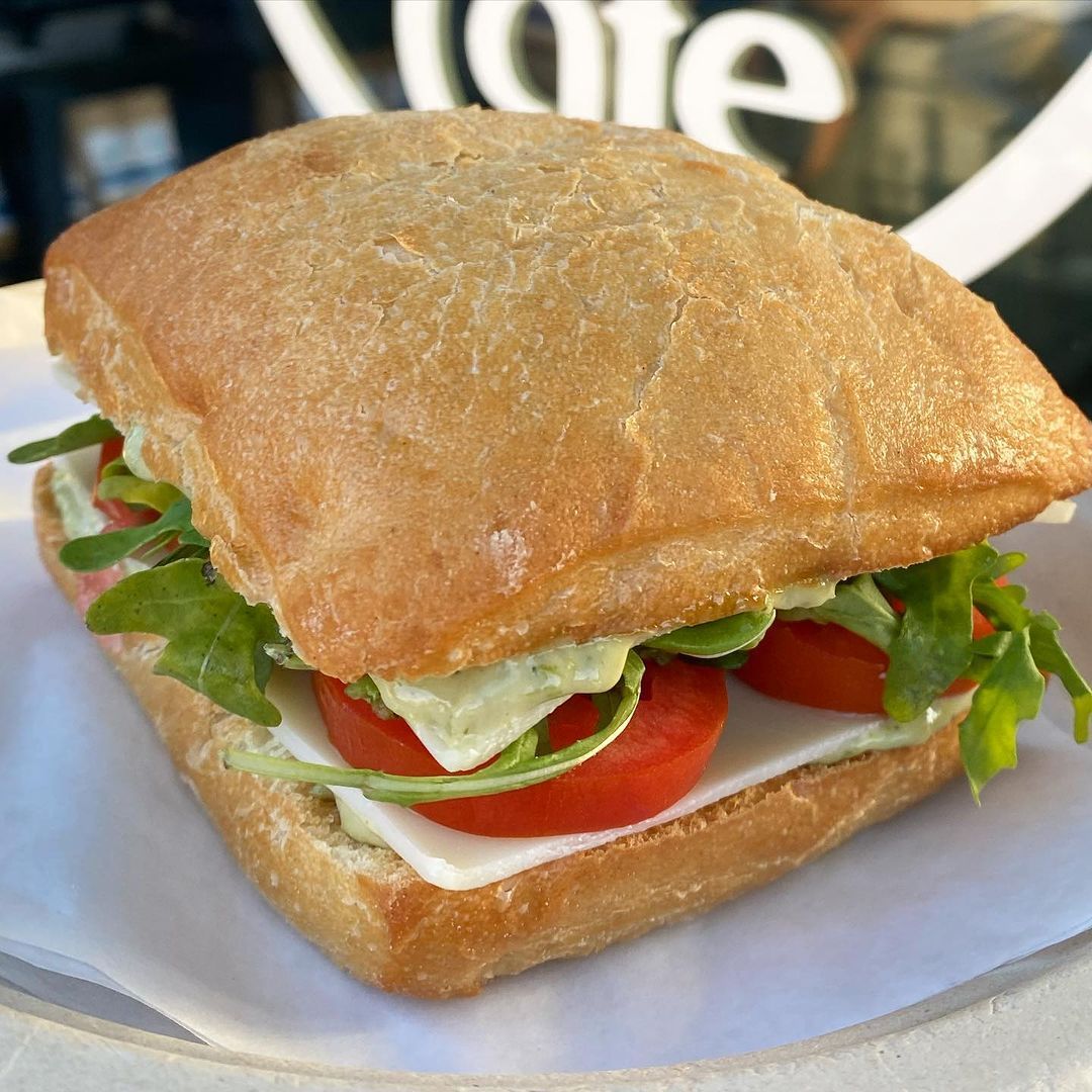 A close up of a sandwich with tomatoes and cheese on a plate