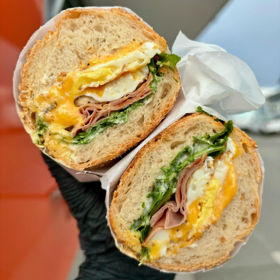 A person is holding two halves of a sandwich in their hand