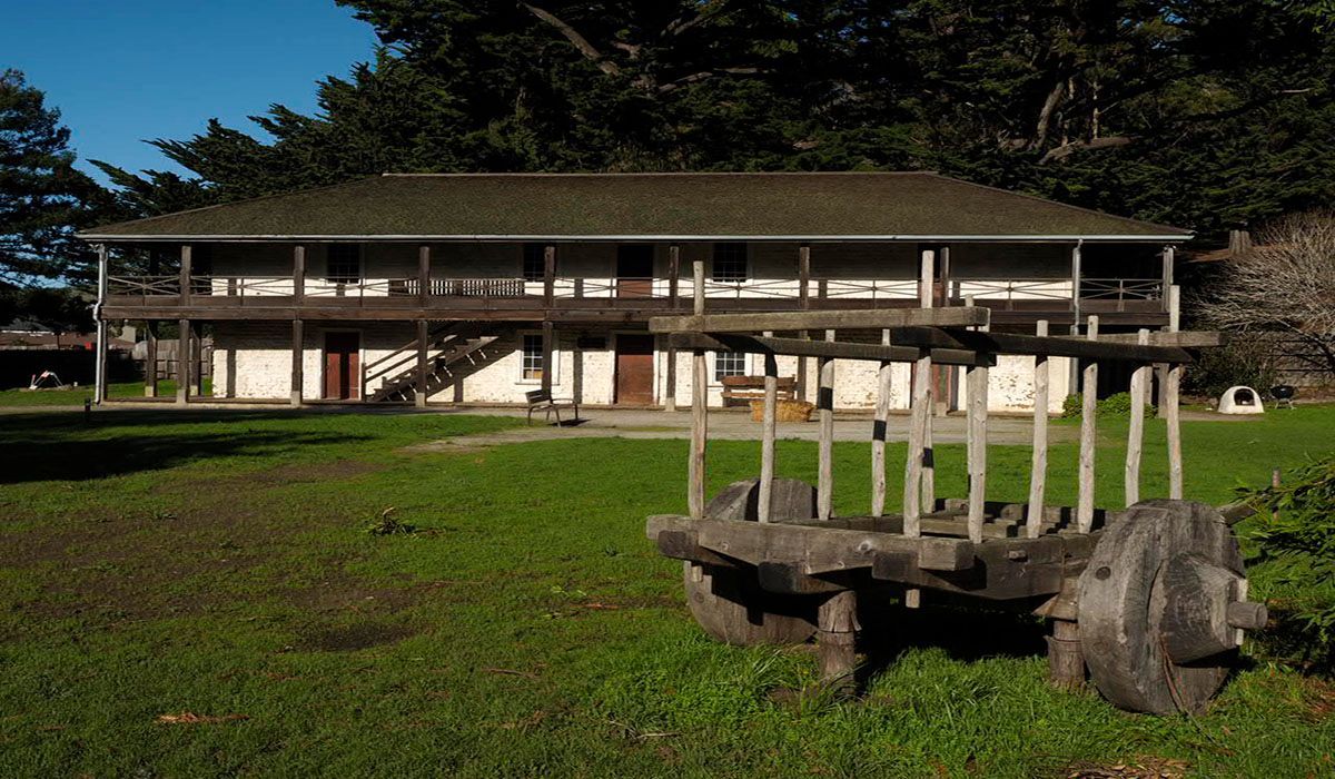 A large house with a wooden cart in front of it.