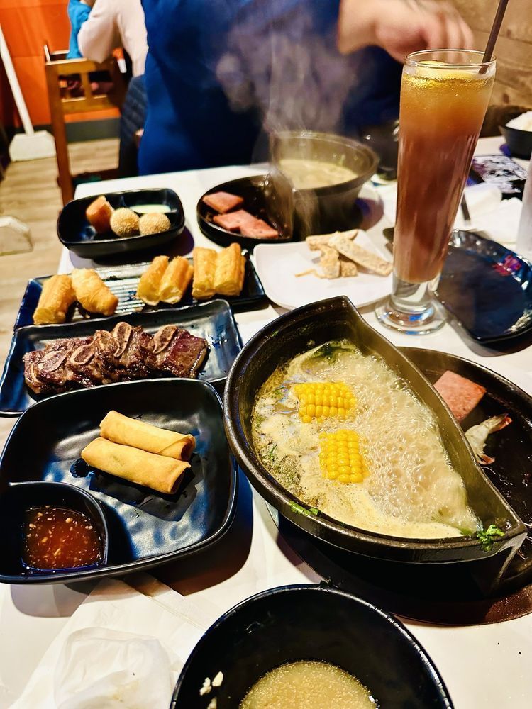 A table topped with bowls of food and a drink.