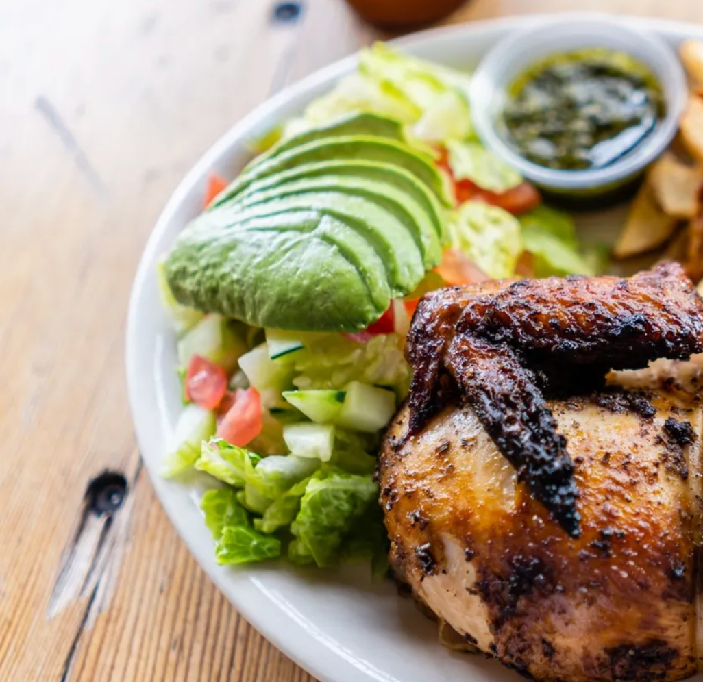 A plate of food with chicken and avocado on it