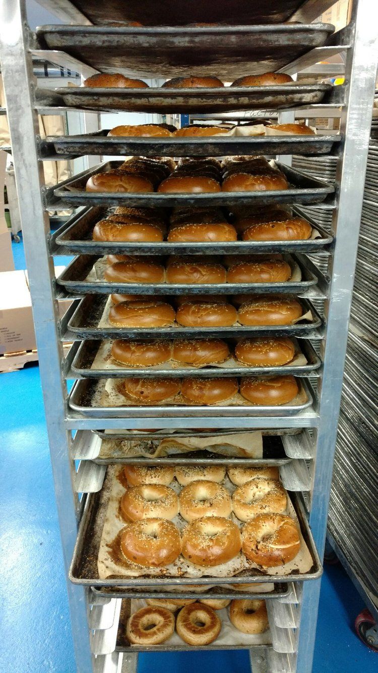 A bunch of donuts are sitting on a rack in a bakery.
