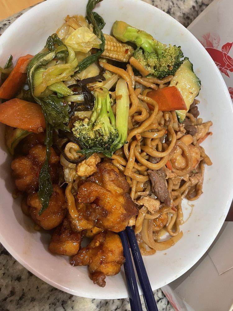 A close up of a plate of food with chopsticks on a table.