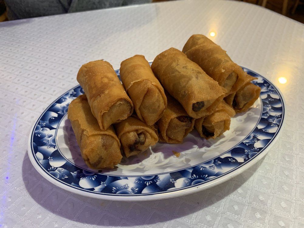 A plate of spring rolls is sitting on a table.