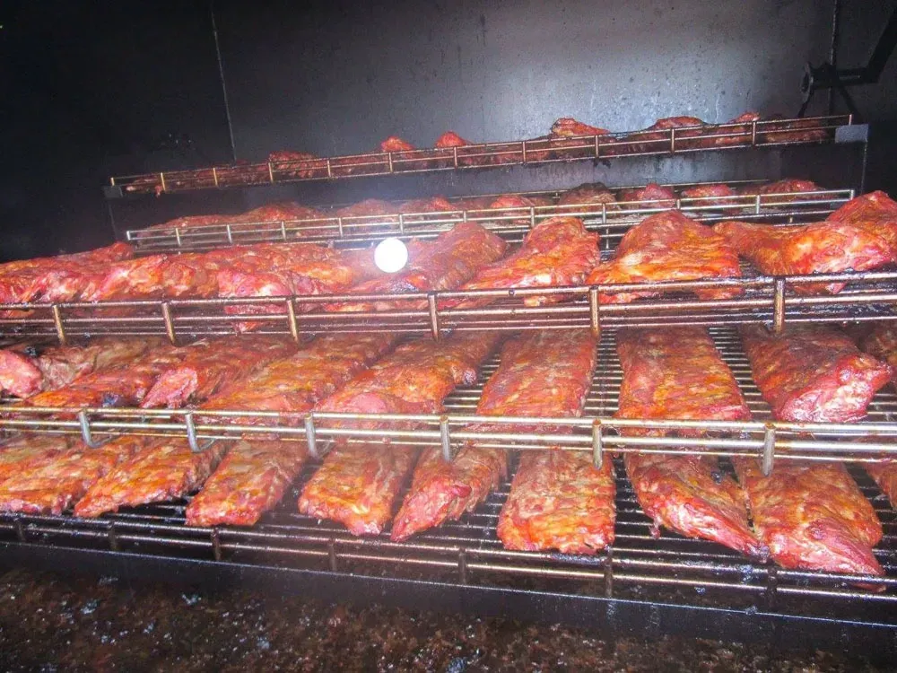 A bunch of meat is being cooked on a grill