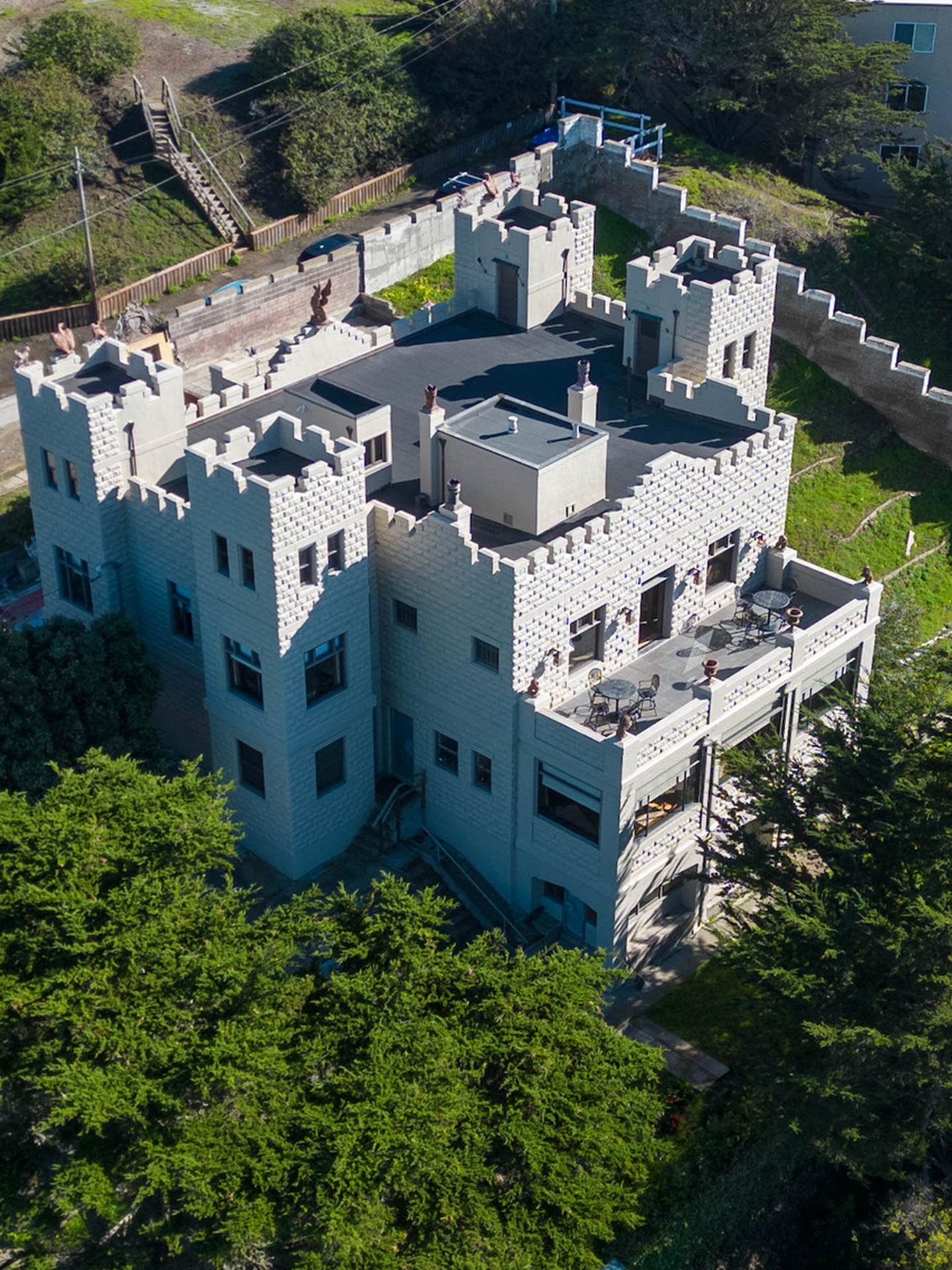 An aerial view of a large white castle surrounded by trees.