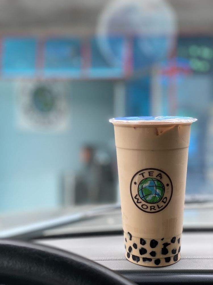 A cup of tea is sitting on the dashboard of a car.