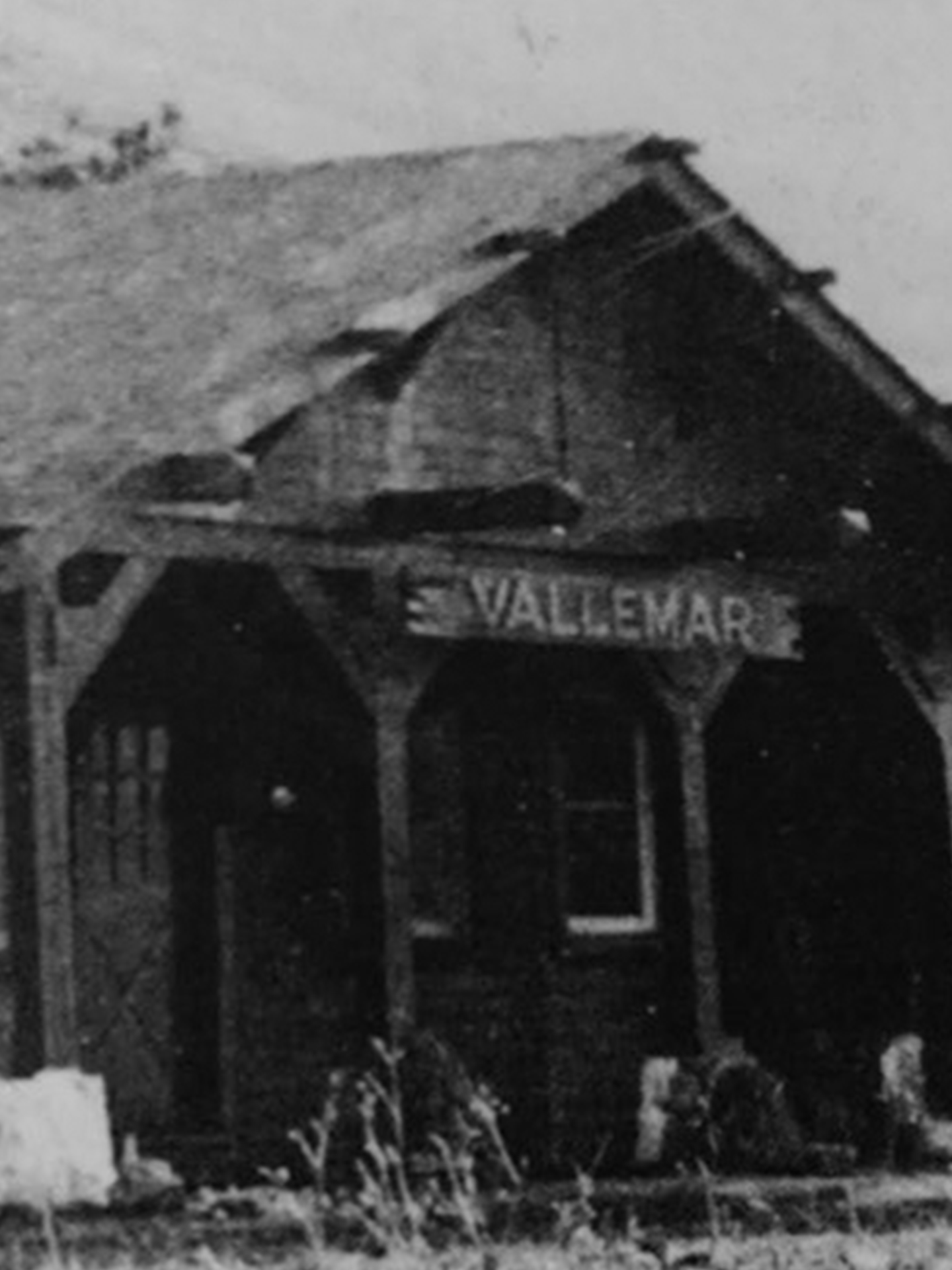 A black and white photo of an old building with a sign that says vallemar.