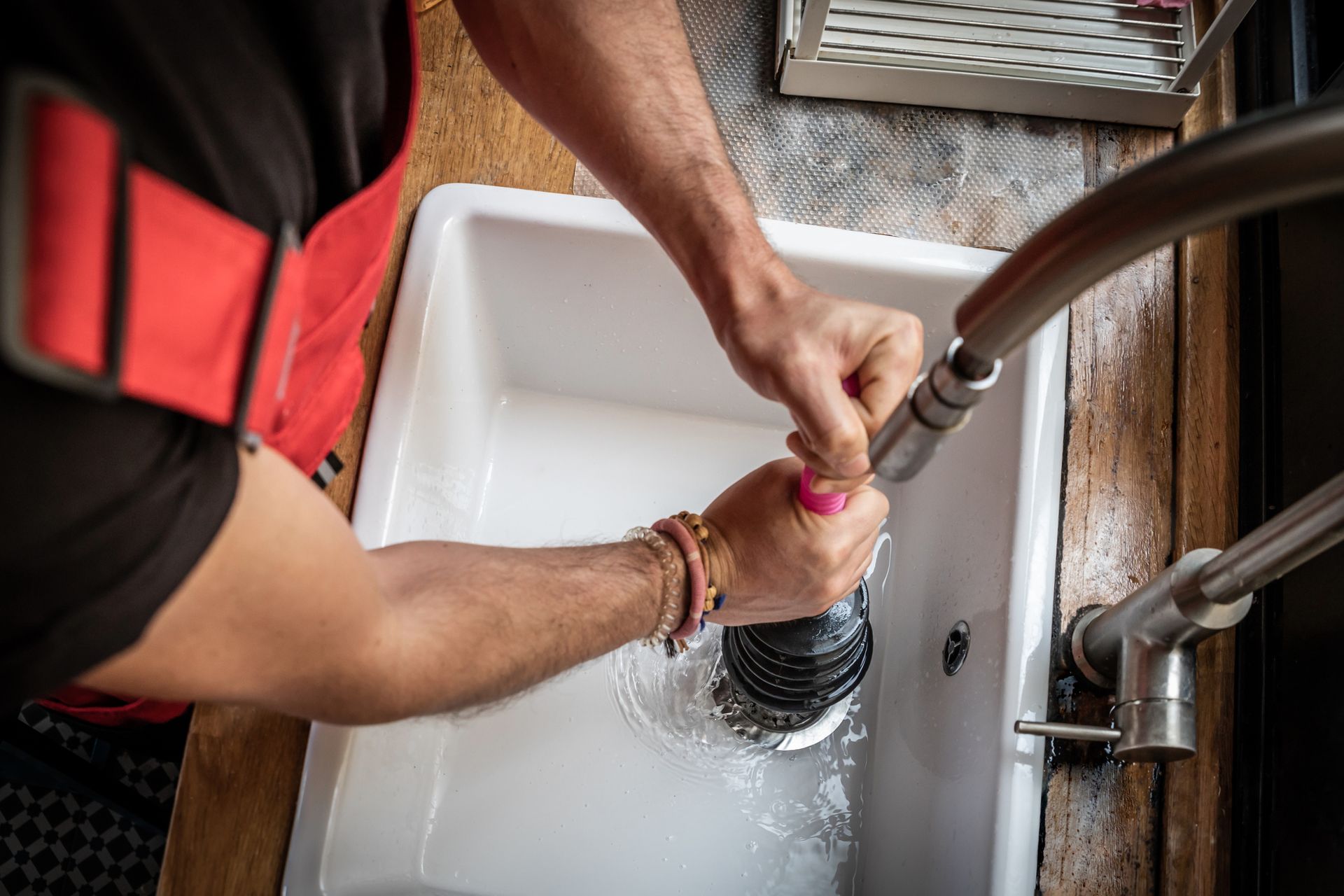 Residential plumber unclogging a sink.