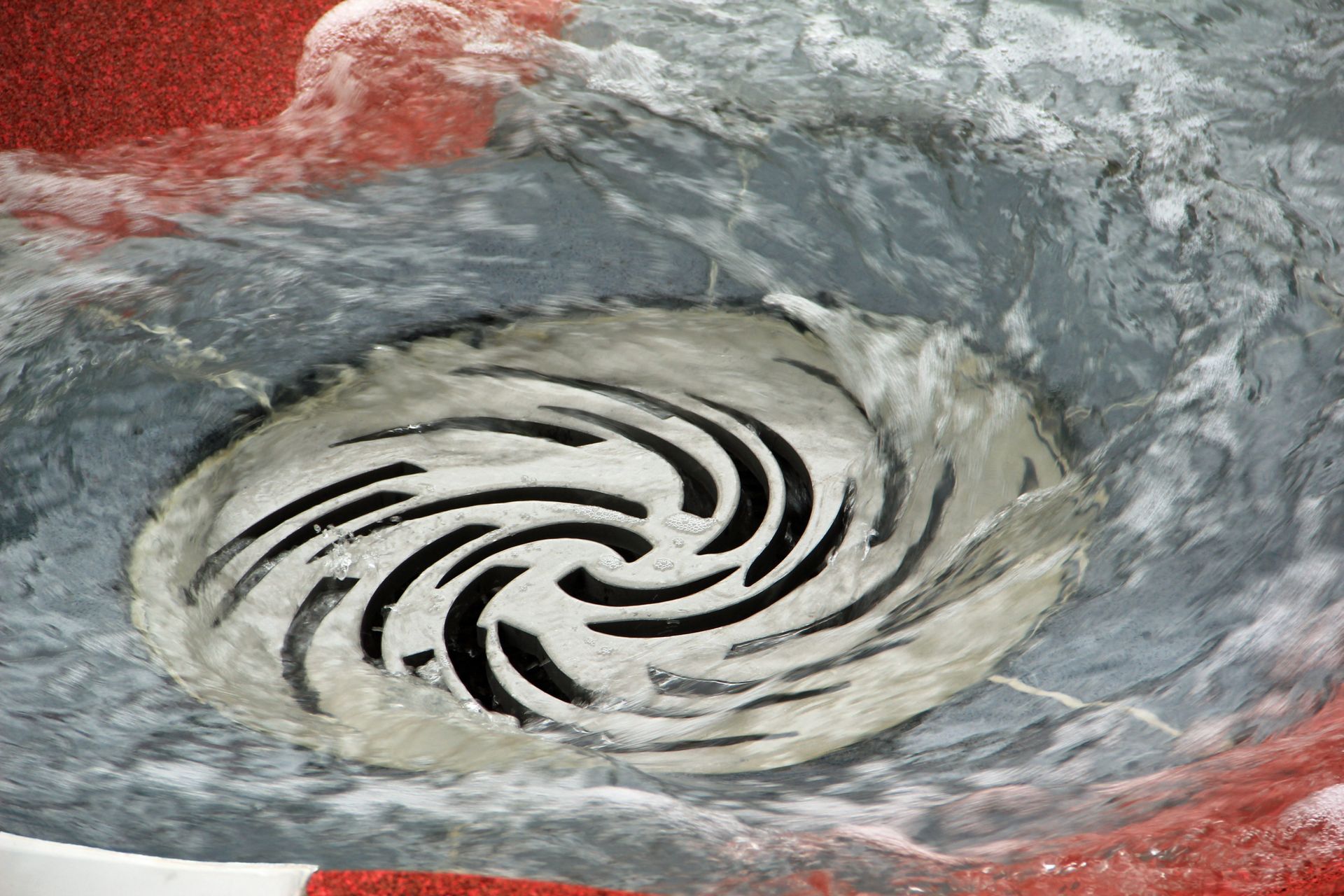 A close up of a drain with water coming out of it.