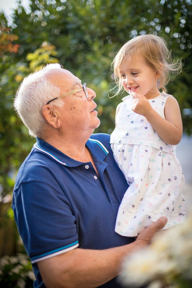 A man is holding a little girl in his arms.