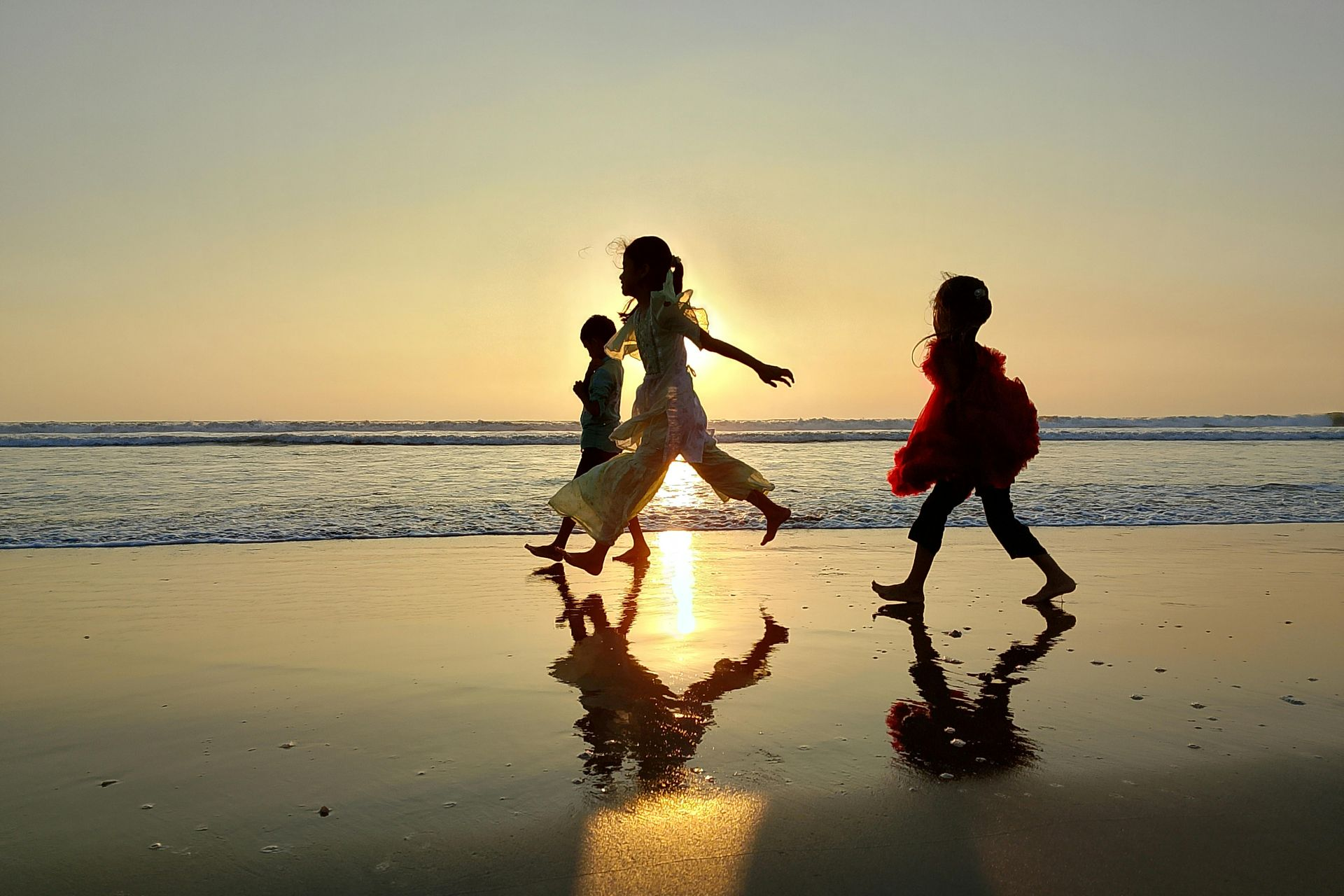 Two young boys are playing in the water on the beach.
