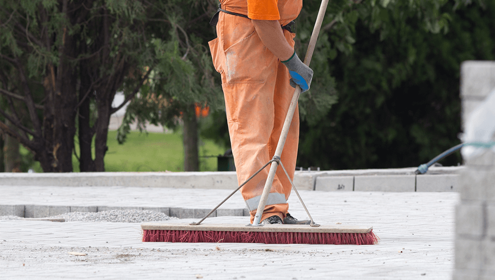 Construction worker sweeping on the building site