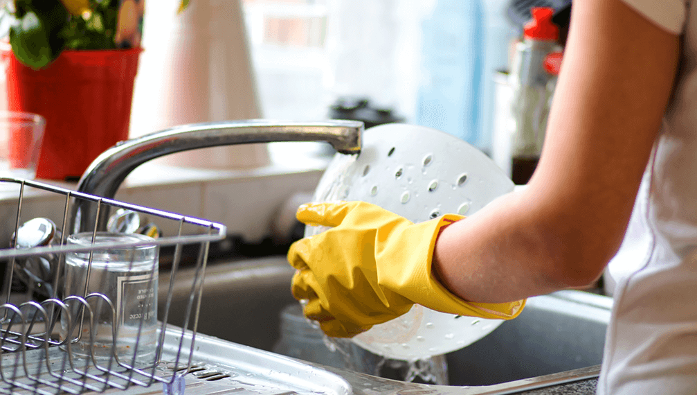 Woman washing dishes in the kitchen. Close up of woman hand. Housewife clean dishes.