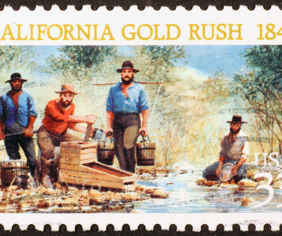 Photo of four men with buckets and other tools looking for gold in a California river, depicting the California gold rush era.