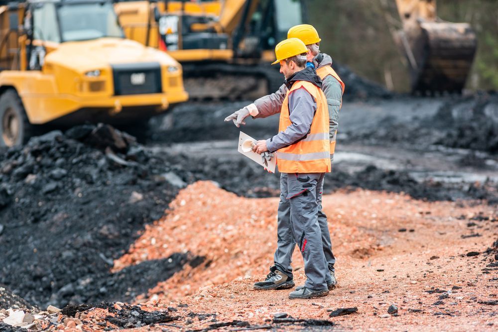Dos trabajadores de la construcción con chalecos de seguridad y cascos