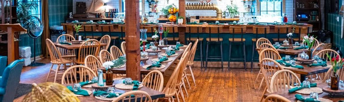 A restaurant filled with tables and chairs and a bar.
