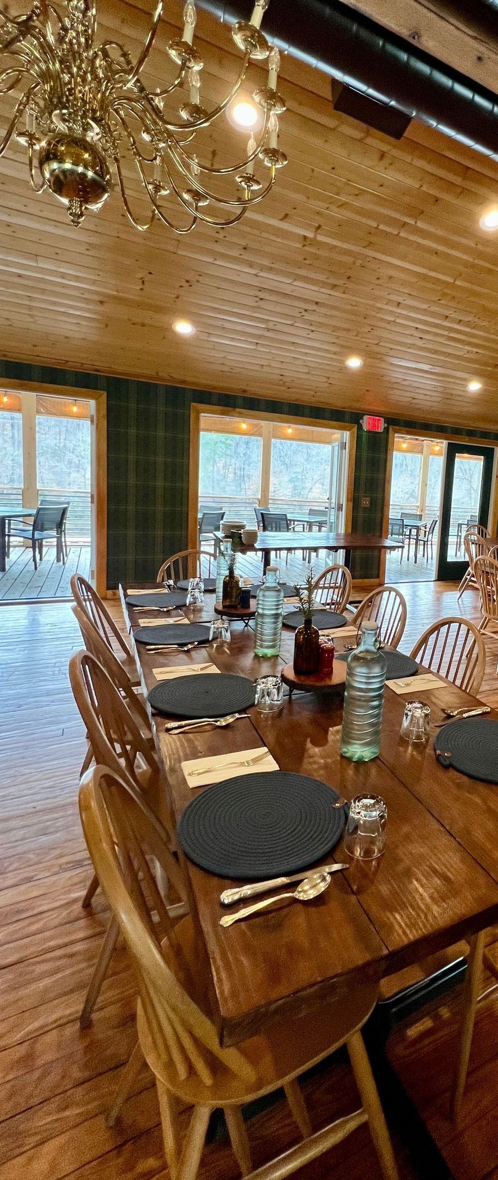 A dining room with a long wooden table and chairs and a chandelier.