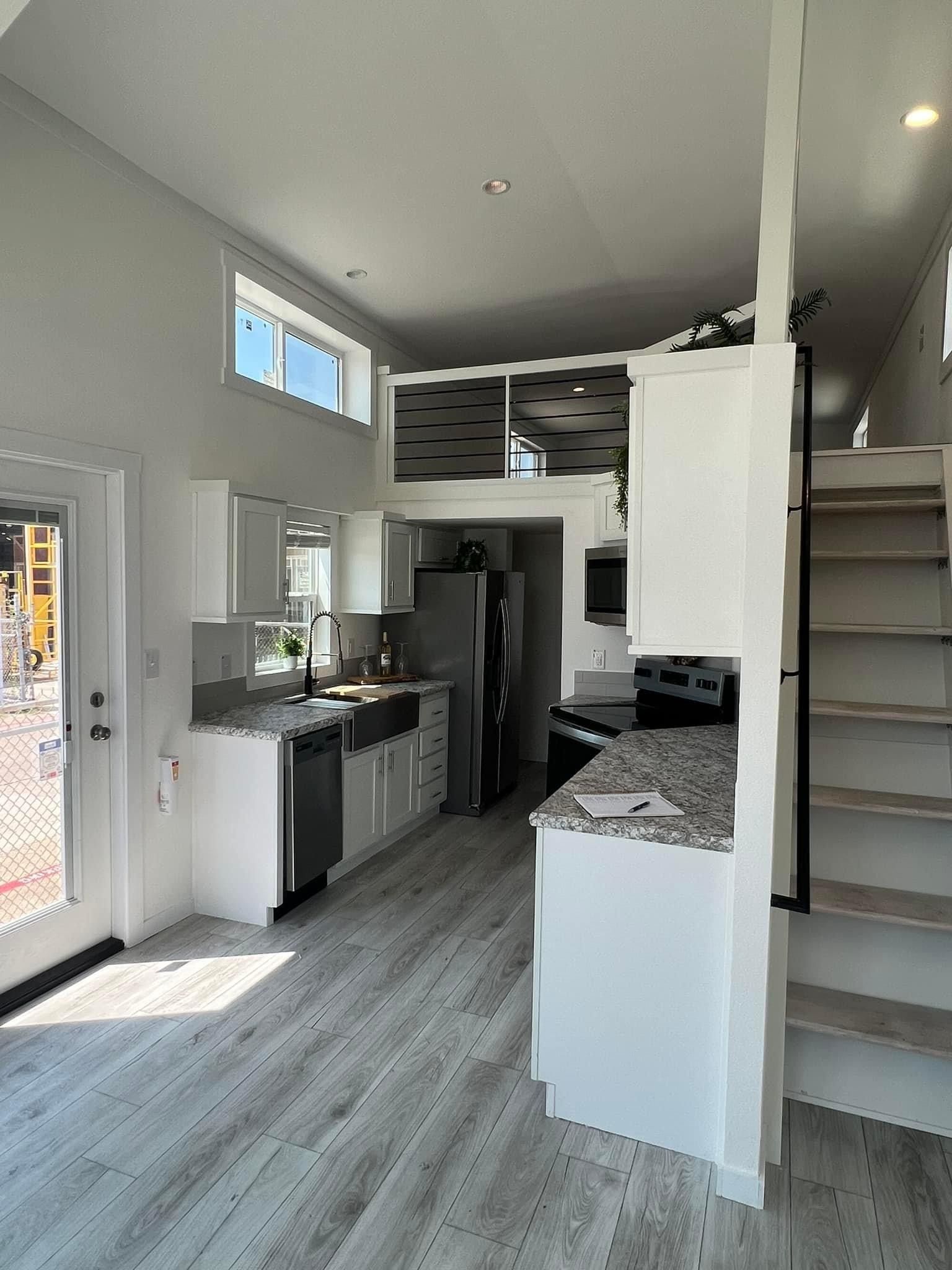 A kitchen with a staircase leading up to the second floor.