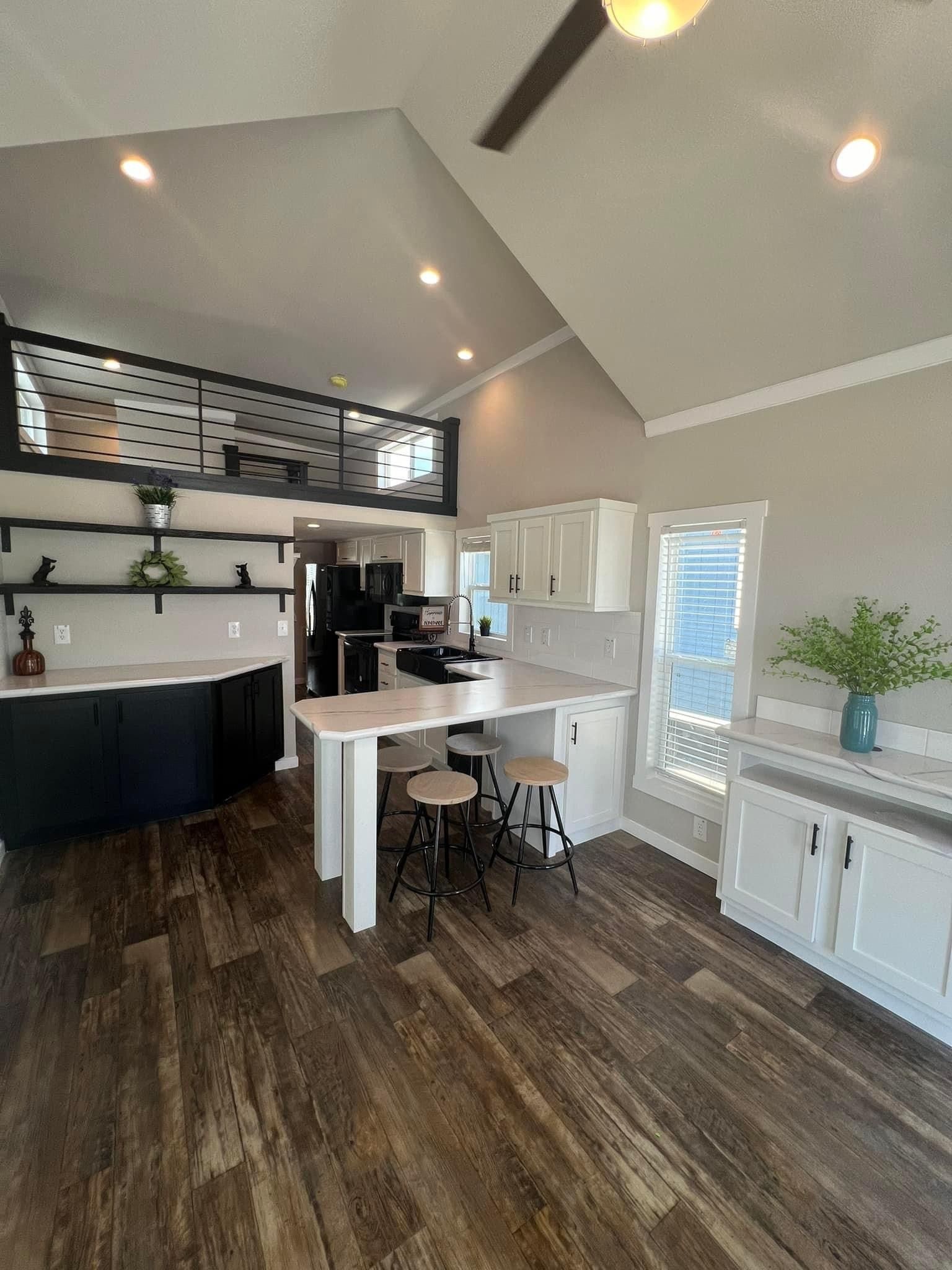 A kitchen in a mobile home with a table and stools.