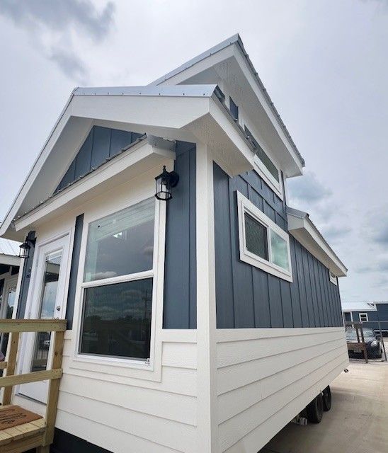 A small house with blue siding and white trim.