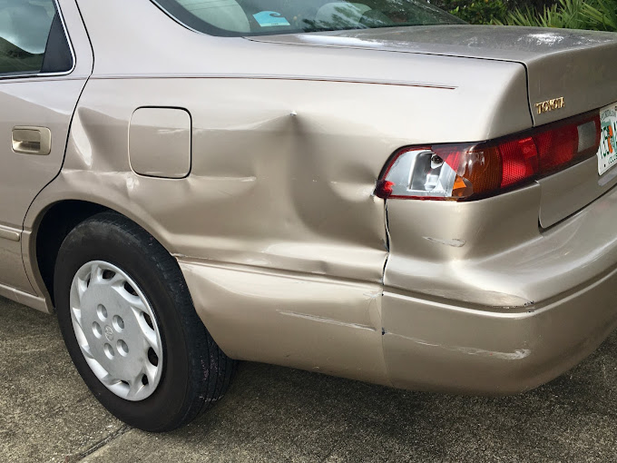 A car with a damaged bumper is parked on the side of the road | Morrison Corp Mobile Body & Paint