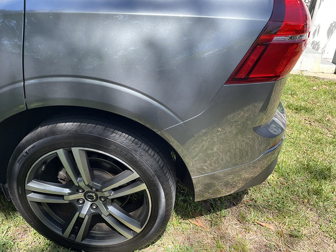 A close up of a car 's rear wheel on a lush green field. | Morrison Corp Mobile Body & Paint