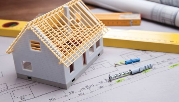 A model house is sitting on top of a blueprint.