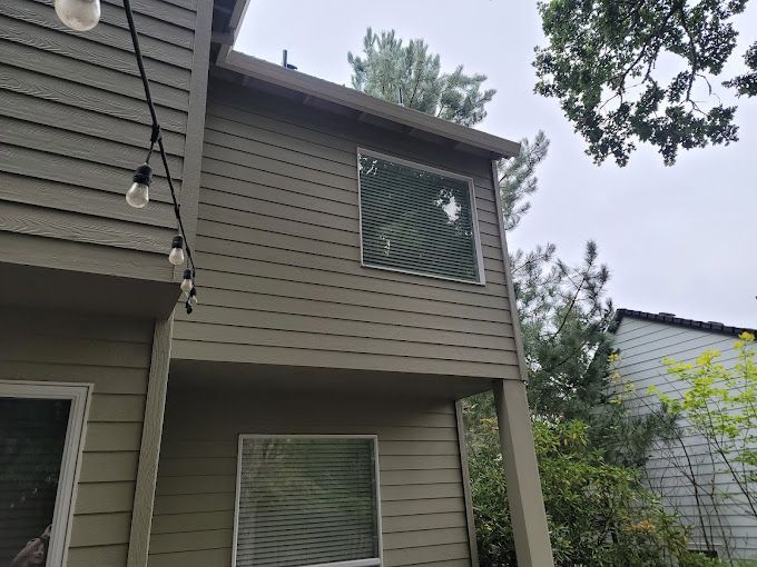 A house with a lot of windows and trees in the background.