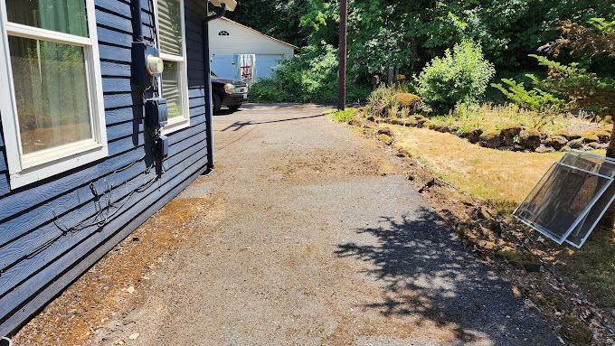 A blue house with a driveway leading to it