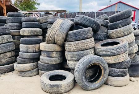 Stacks of used tires in an outdoor yard.