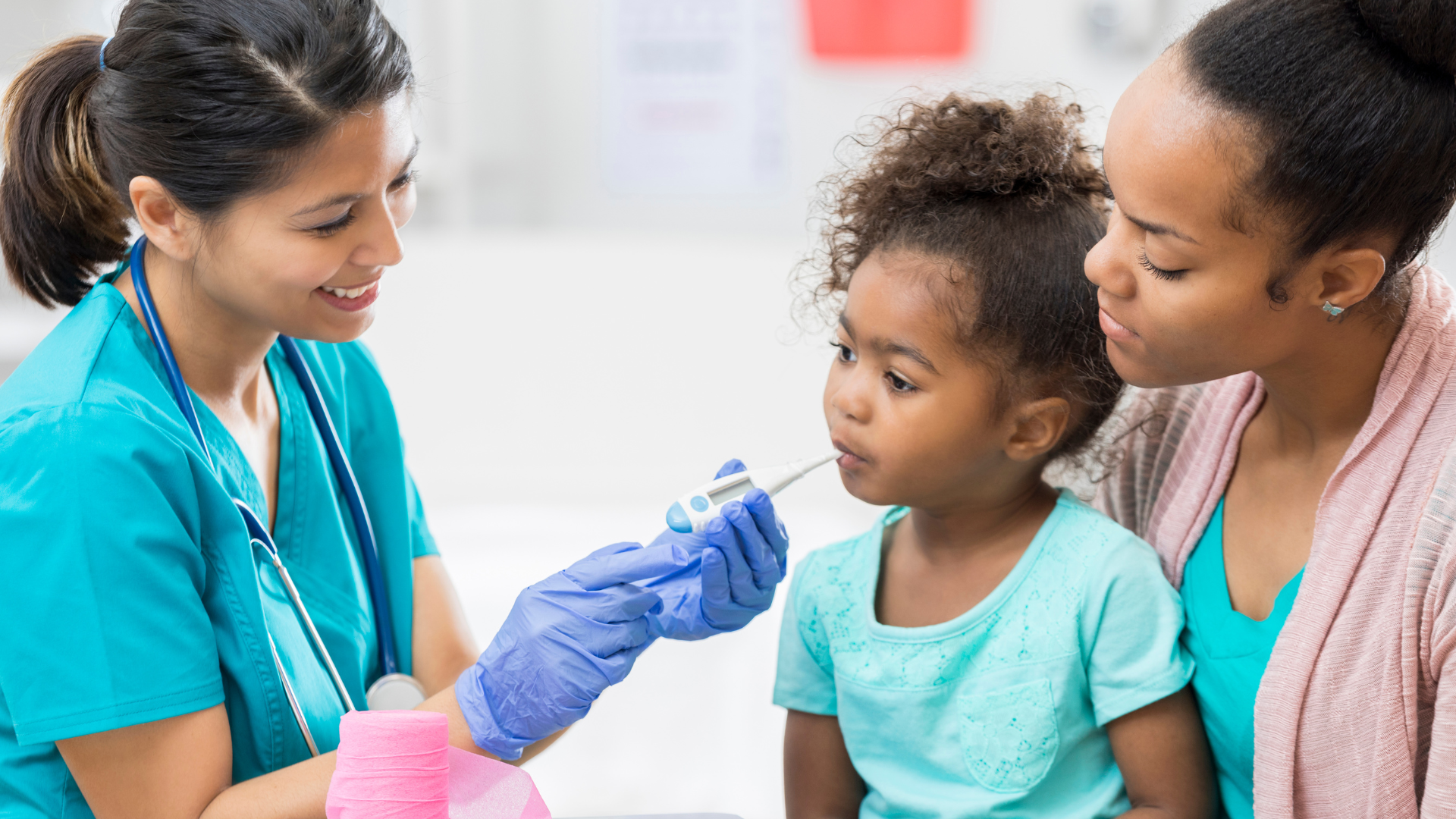 A doctor is holding a baby girl in her arms.