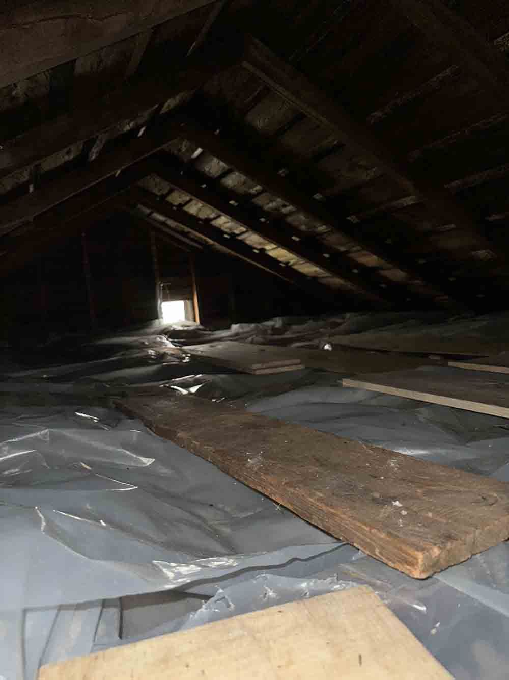 the attic is covered in plastic and wooden planks