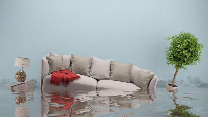 a flooded living room with a couch and a lamp