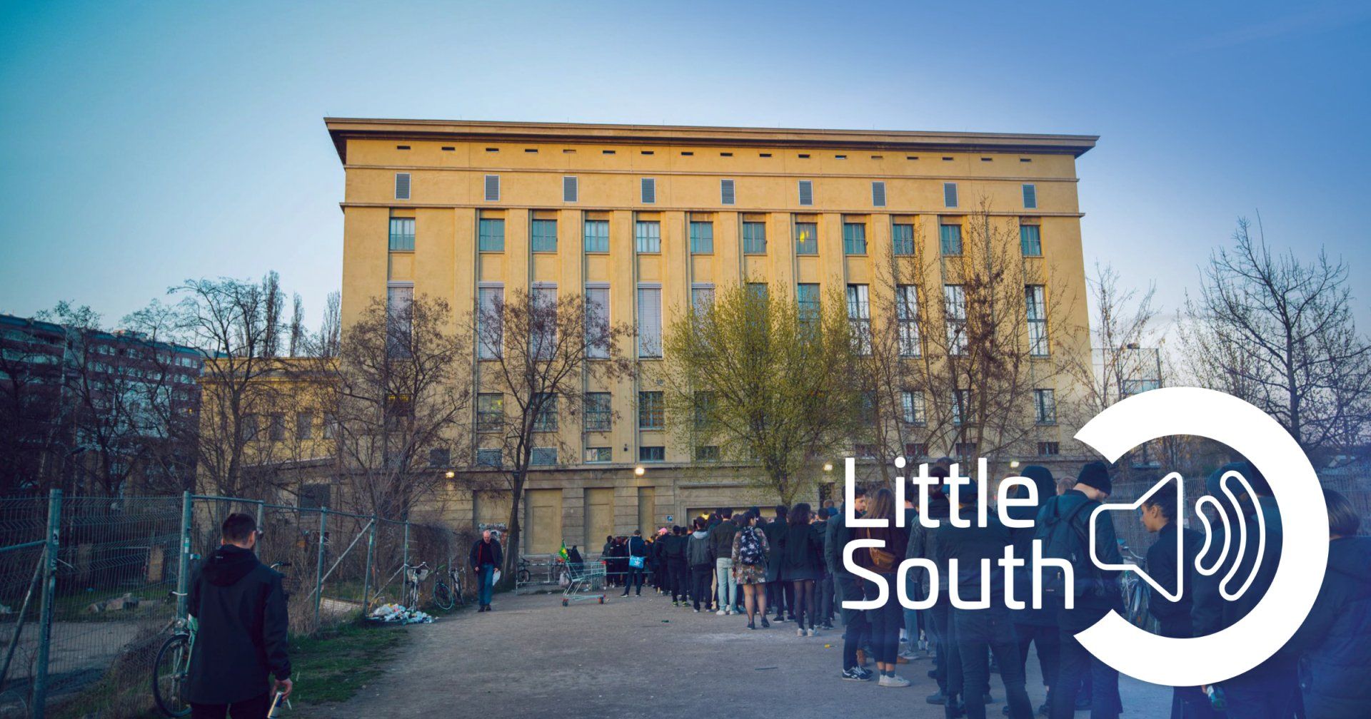 A group of people standing in front of a building that says little south