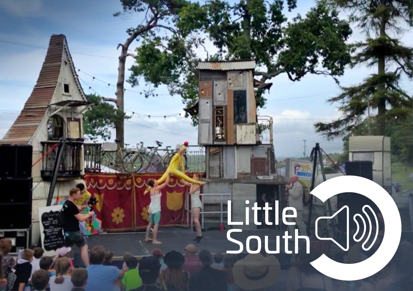 A group of people are watching a performance by little south